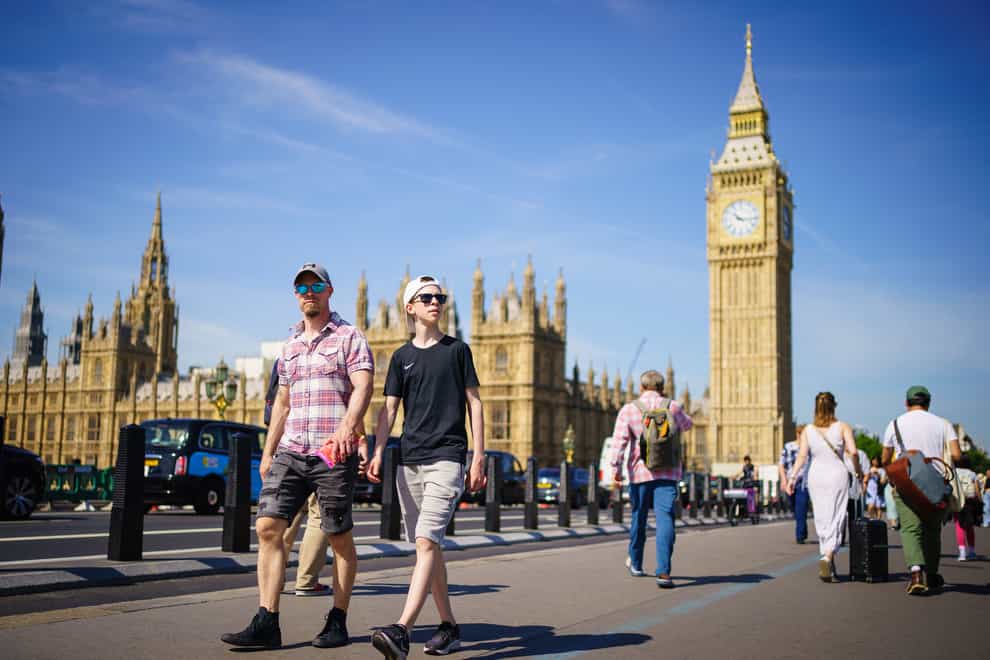 People enjoy the sunny weather on Westminster Bridge, by the Houses of Parliament, London (Dominic Lipinski/PA)