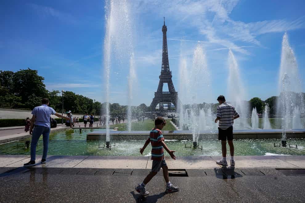 People cool off at the fountain of the Trocadero garden next to the Eiffel Tower in Paris, Thursday, June 16, 2022. Hot weather is expected to last for several days across the country. (AP Photo/Michel Euler)