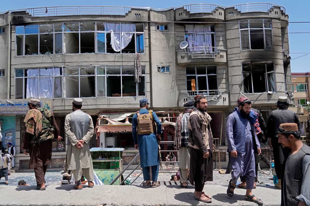 Taliban fighters stand guard at the site of an explosion in front of a Sikh temple in Kabul (Ebrahim Noroozi/AP)