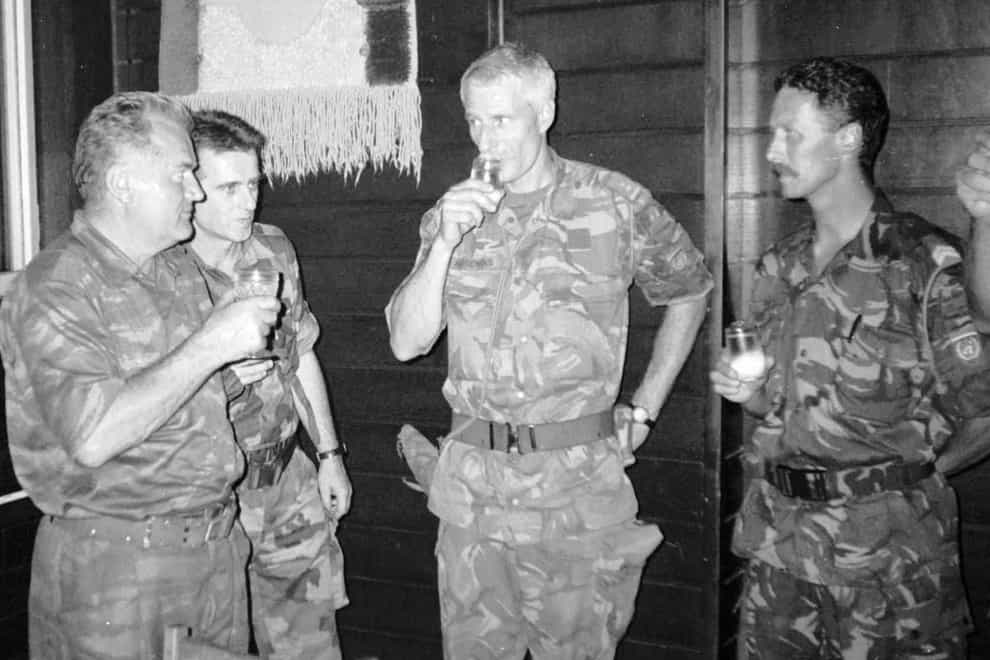 Bosnian Serb army Commander General Ratko Mladic, left, drinks with Dutch UN Commander Tom Karremans, second right, in Potocari, three miles north of Srebrenica, on July 12 1995 (AP)
