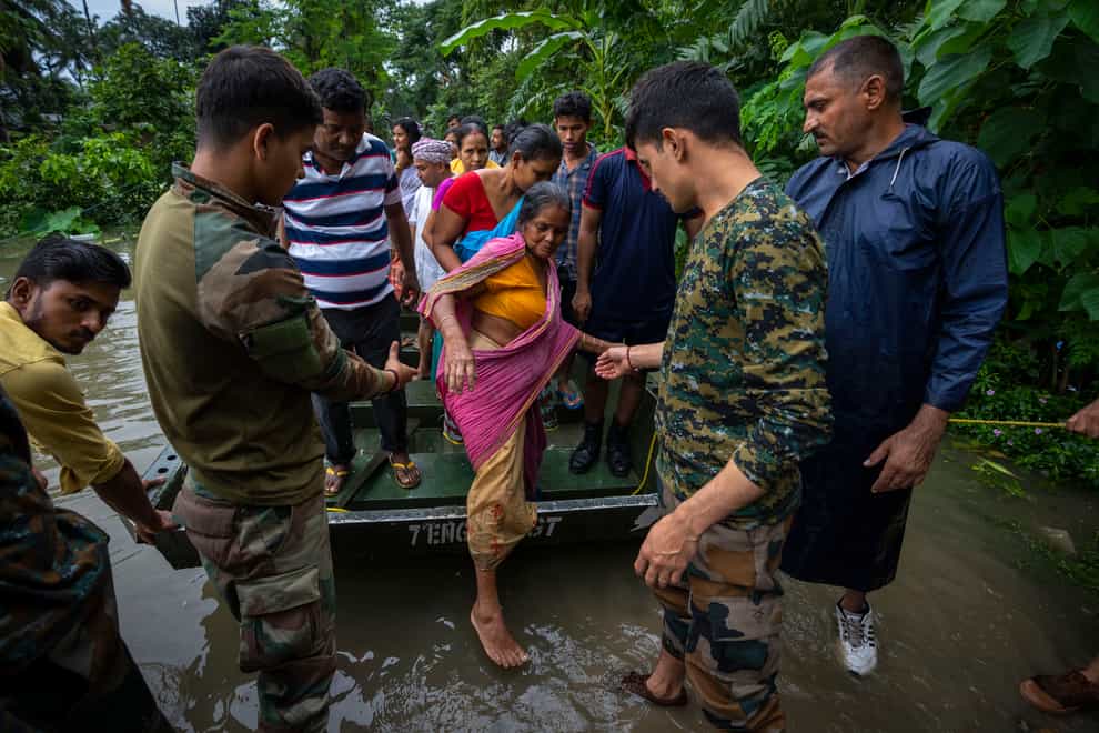 Indian army personnel rescue flood-affected villagers on a boat in Jalimura village, west of Gauhati (Anupam Nath/AP)