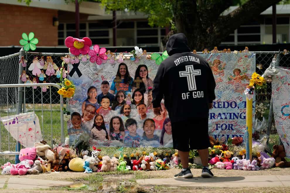 A mourner stops to pay his respects at a memorial at Robb Elementary School (AP)