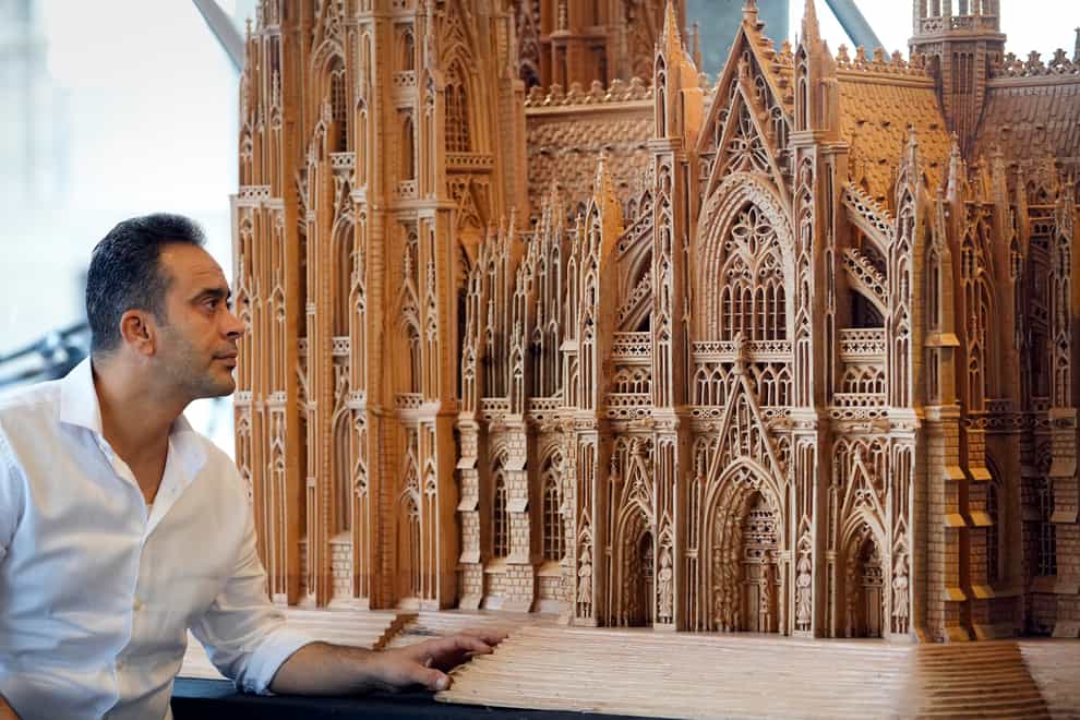 Fadel Alkhudr from Syria poses near the south part of his wooden model of Cologne Cathedral on display at the Domforum in Cologne, Germany (Martin Meissner/AP)