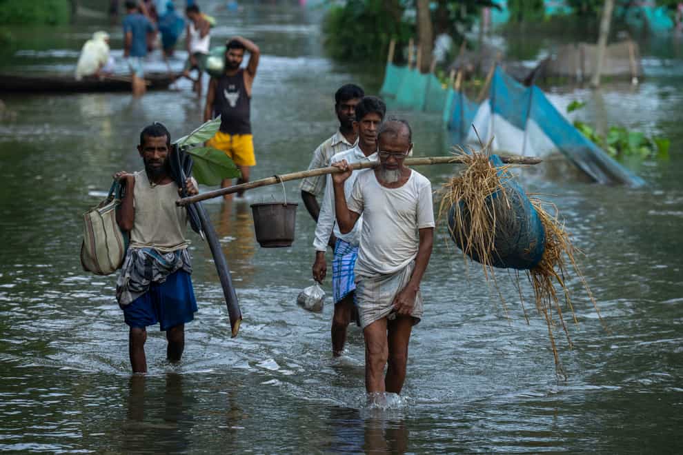 Flood-affected people walk to safer places from their marooned Tarabari village, west of Gauhati, in the north-eastern Indian state of Assam (Anupam Nath/AP)