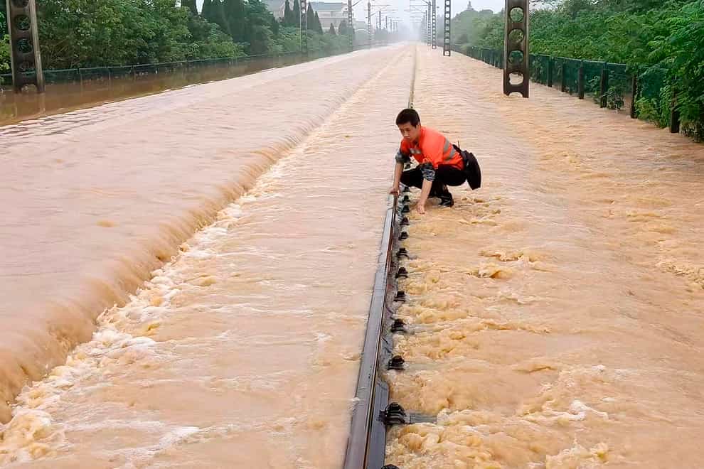 A worker checks a section of flooded railway in Shangrao in central China’s Jiangxi province (Chinatopix via AP)