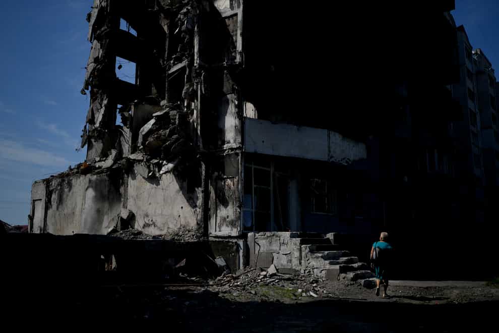 A woman walks past a building destroyed in Russian shelling in Borodyanka, on the outskirts of Kyiv (AP)
