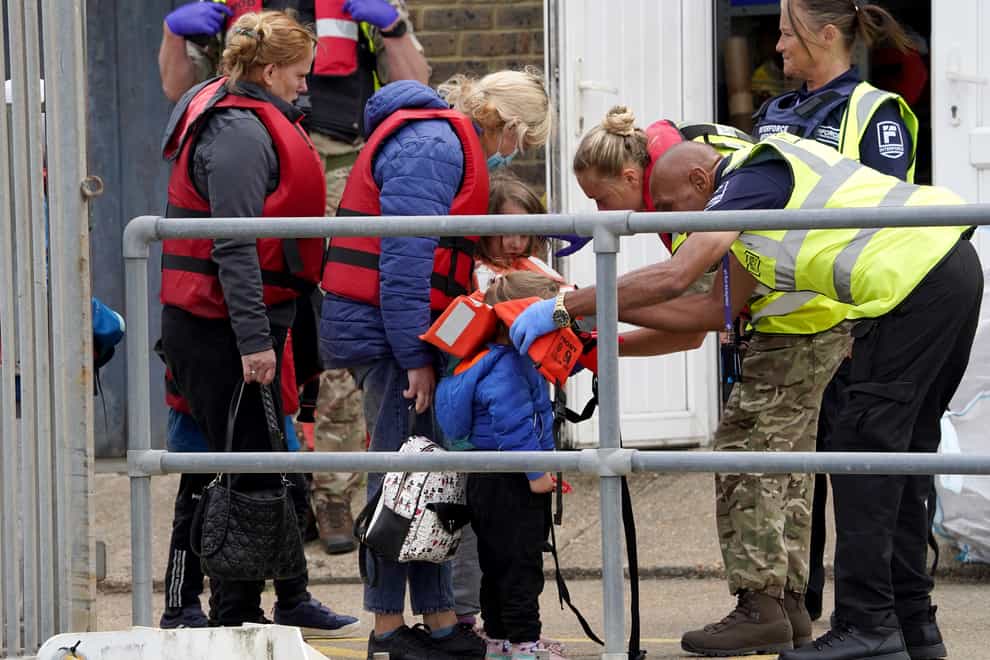 A young child is helped amongst a group of people thought to be migrants as they are brought in to Dover, Kent (Gareth Fuller/PA)