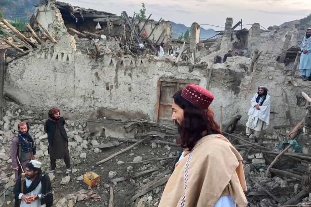 Afghans look at destruction caused by an earthquake in the province of Paktika, eastern Afghanistan (Bakhtar News Agency/AP)