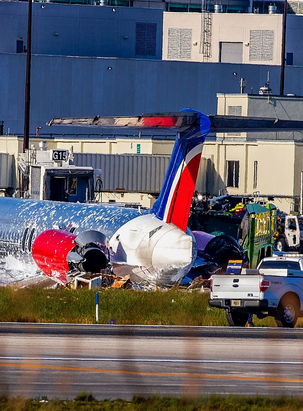 Firefighting units are seen next to a Red Air plane that caught fire after the front landing gear collapsed upon landing at Miami International Airport (Pedro Portal/Miami Herald/AP)