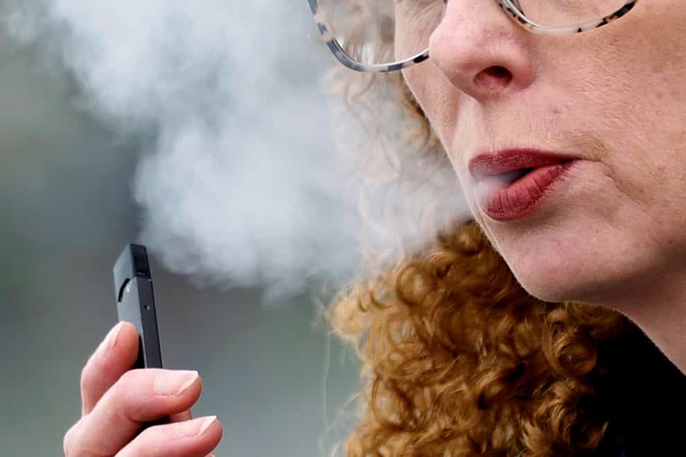A woman exhales while vaping from a Juul pen e-cigarette(Craig Mitchelldyer/AP)