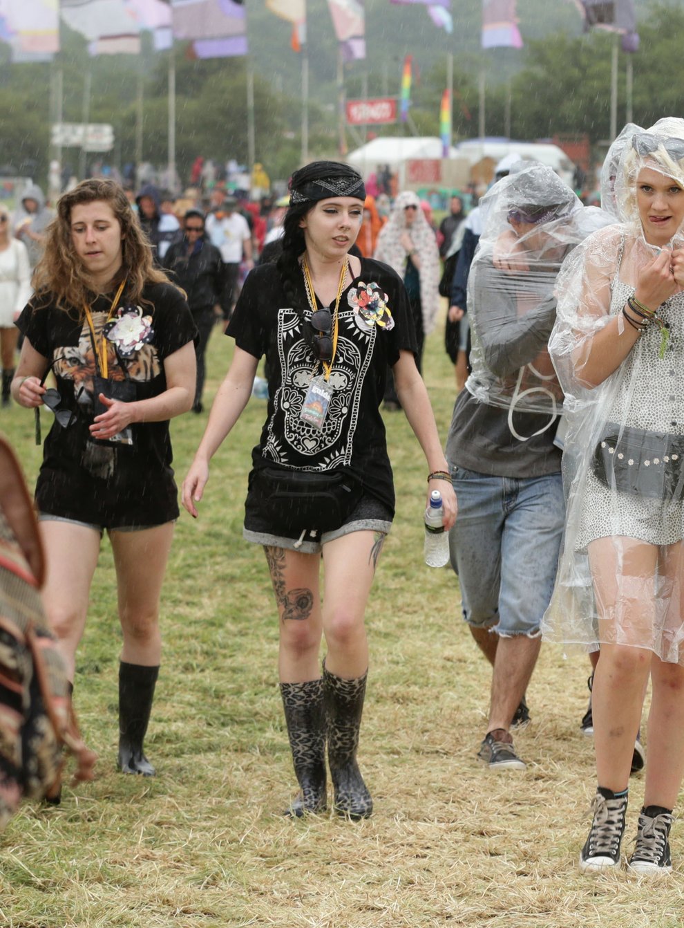 Festival goers during a rain shower at the Glastonbury Festival (PA)