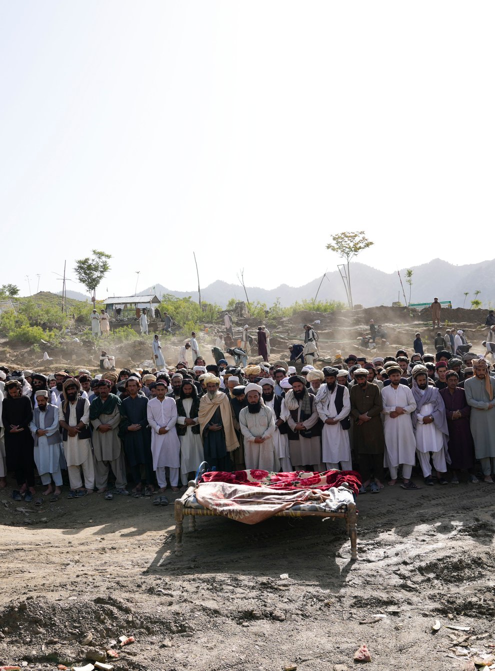 Afghans pray for relatives killed in the earthquake at a burial site in Gayan village, Paktika province (Ebrahim Nooroozi/AP)