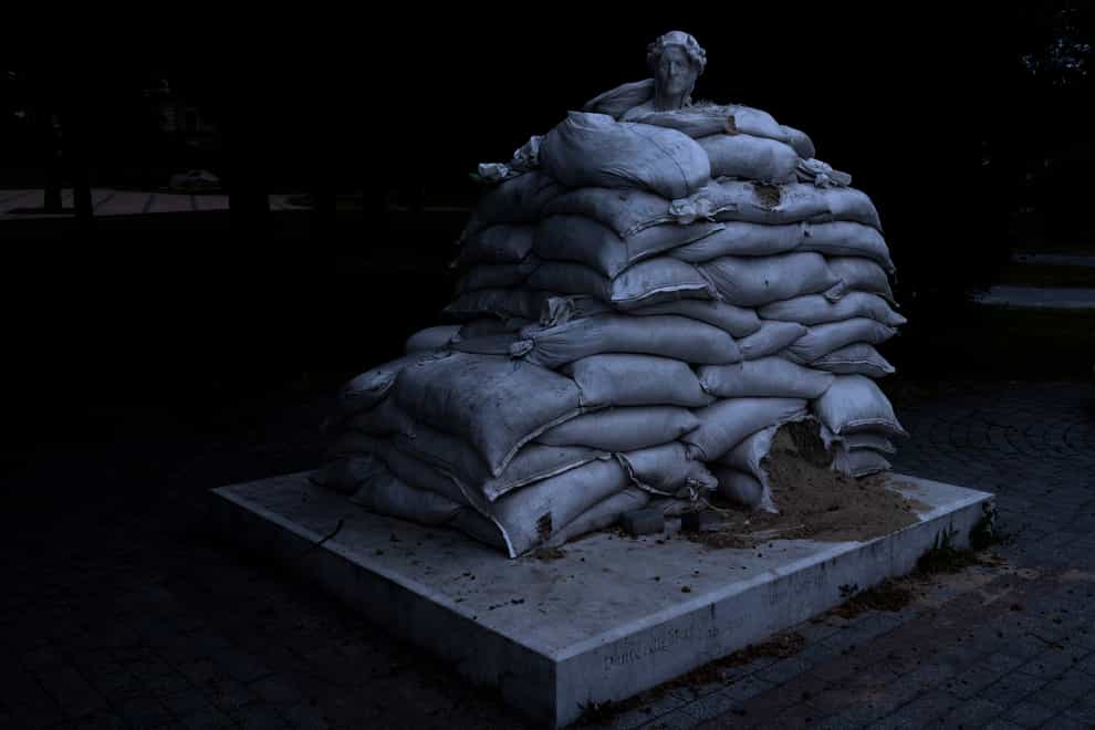 The sculpture of prominent Italian poet Dante Alighieri is protected by sandbags, on Vladimir’s Hill in Kyiv, Ukraine (Nariman El-Mofty/AP)