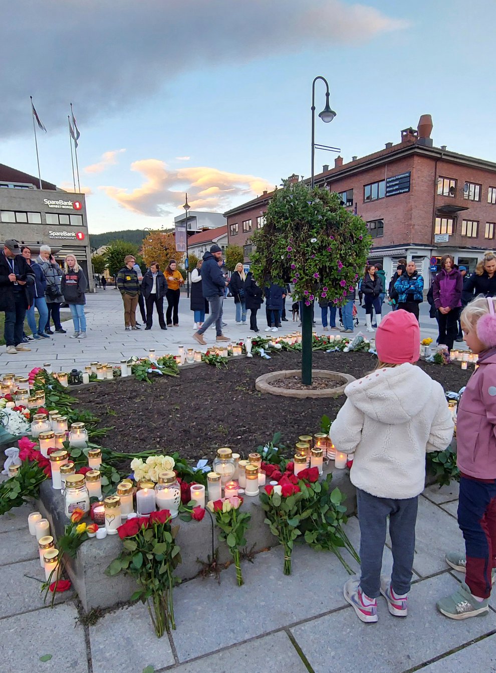 People gather around flowers and candles in Kongsberg (Pal Nordseth/AP)