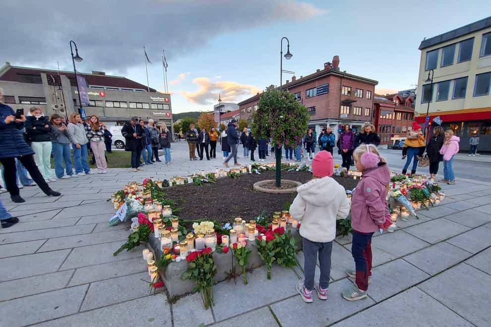 People gather around flowers and candles in Kongsberg (Pal Nordseth/AP)