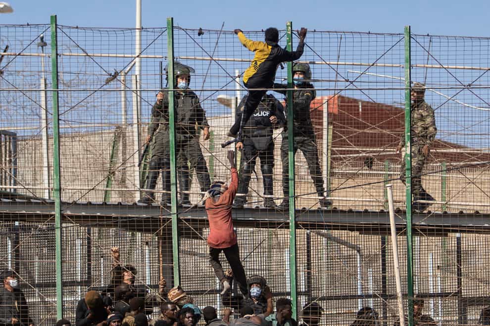Migrants climb the fences separating the Spanish enclave of Melilla from Morocco (Javier Bernardo/AP)