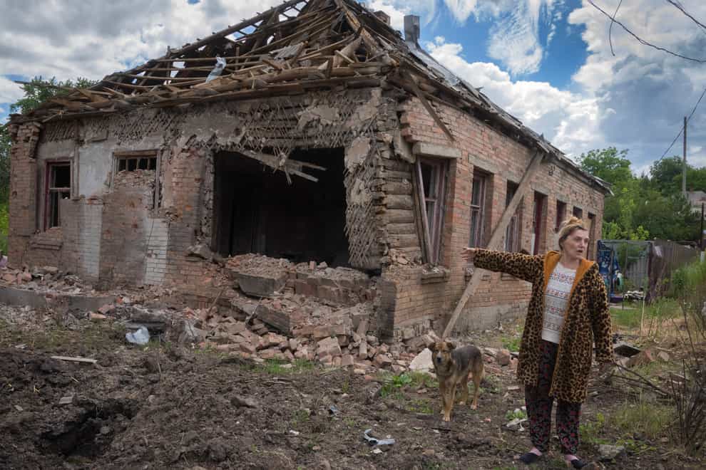 A local resident points at her house heavily damaged by Russian shelling in Bakhmut, Donetsk region, Ukraine (Efrem Lukatsky/AP)