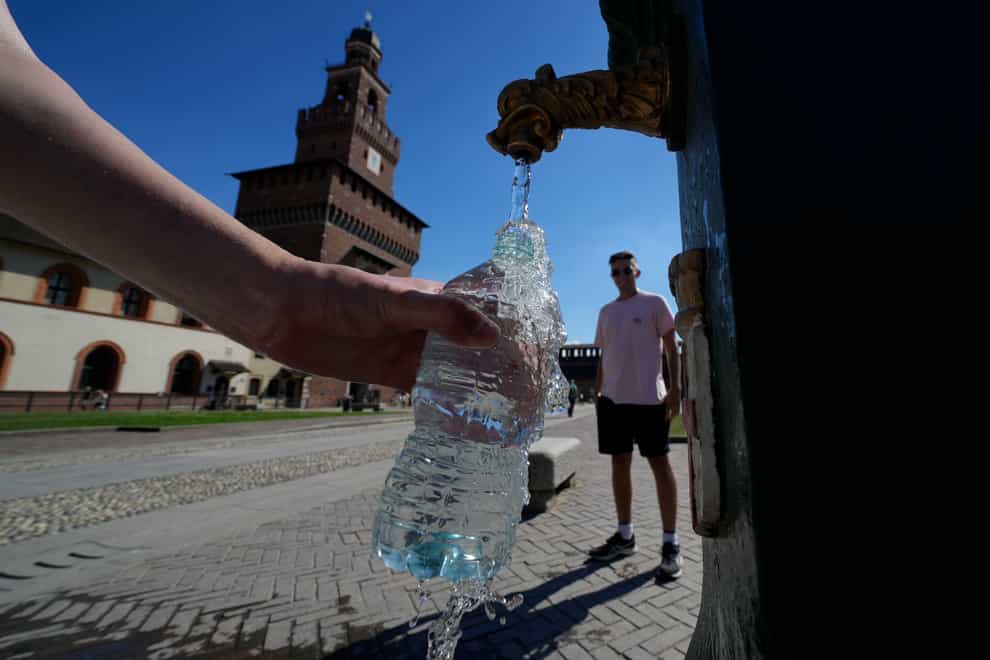 Tourists fill plastic bottles with water from a public fountain at the Sforzesco Castle in Milan, Italy (Luca Bruno/AP)