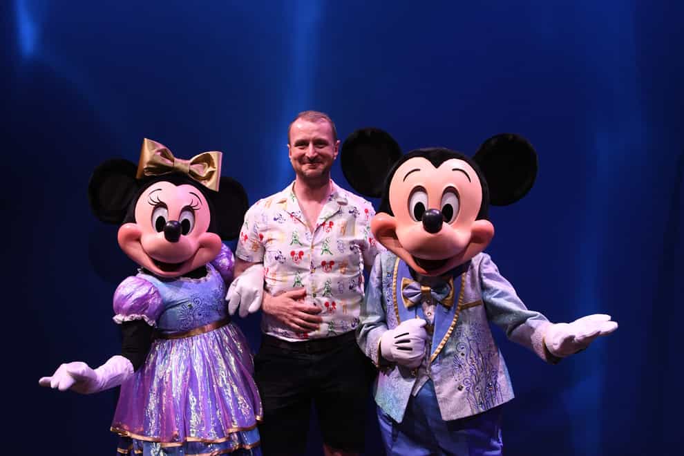 Damon Smith with Minnie Mouse and Mickey Mouse in their 50th anniversary attire (Damon Smith/PA)