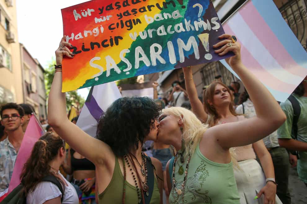 Two women hold up a placard reading: ‘I live free. Who’s the fool who will put me in chains? I would be shocked’ during the LGBTQ Pride March in Istanbul (AP)