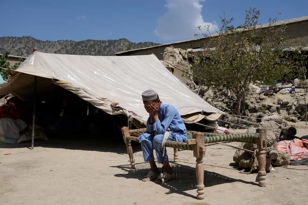 Afghan child sits in a courtyard of their destroyed home after an earthquake in Gayan district in Paktika province (AP)