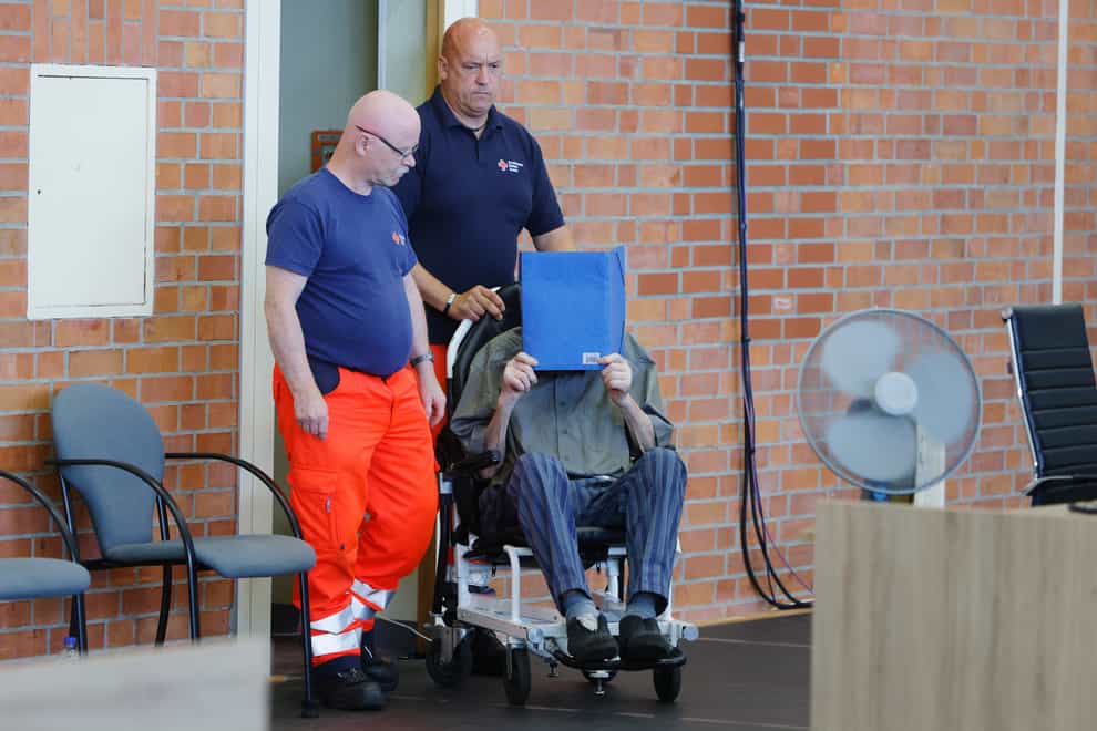 The accused covers his face as he sits at the court room in Brandenburg (AP)