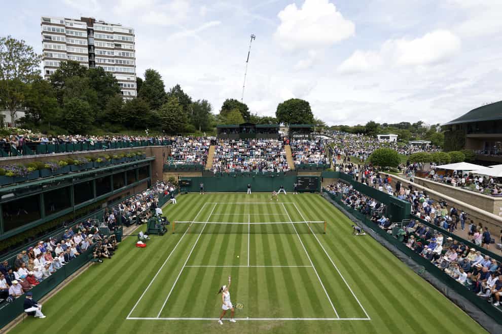 Katie Swan (foreground) serves during her match against Marta Kostyuk during day two of the 2022 Wimbledon Championships (PA)