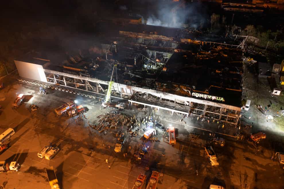Firefighters at the shopping centre in Kremenchuk (AP)