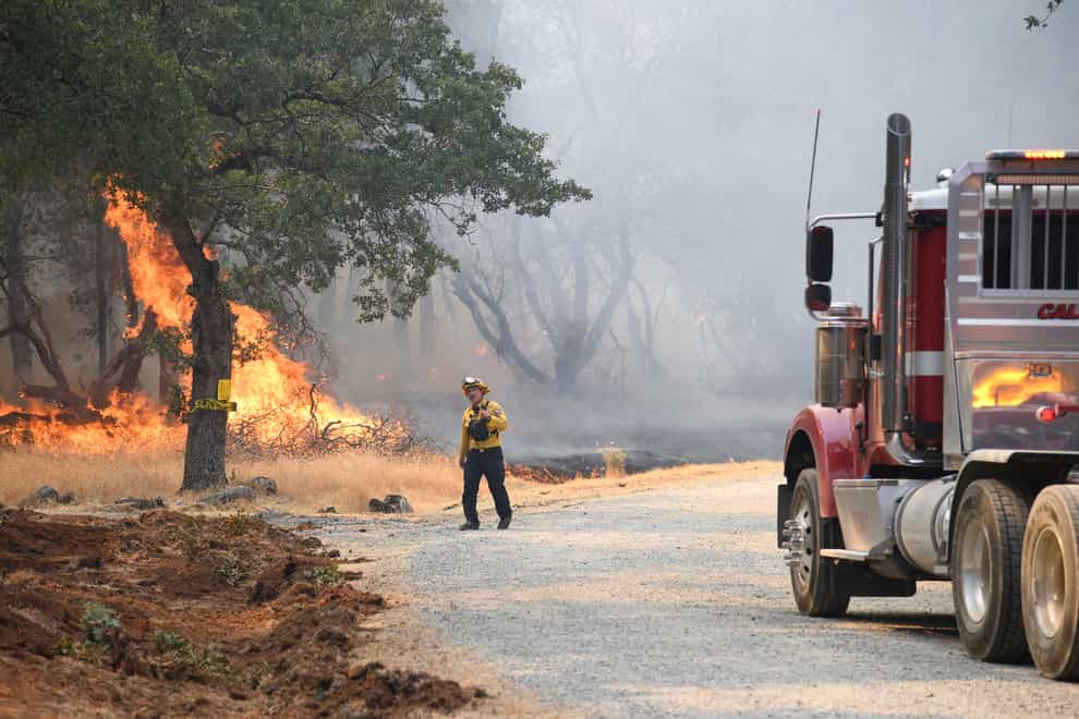 A firefighter assesses the approaching blaze along the Troost Trail in California’s rural Nevada County (Elias Funez/The Union/AP)