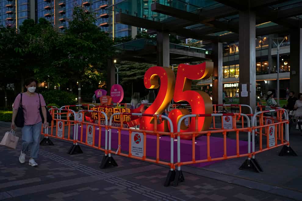 A woman walks past a sculpture marking the 25th anniversary of the handover of Hong Kong to China (Kin Cheung/AP)