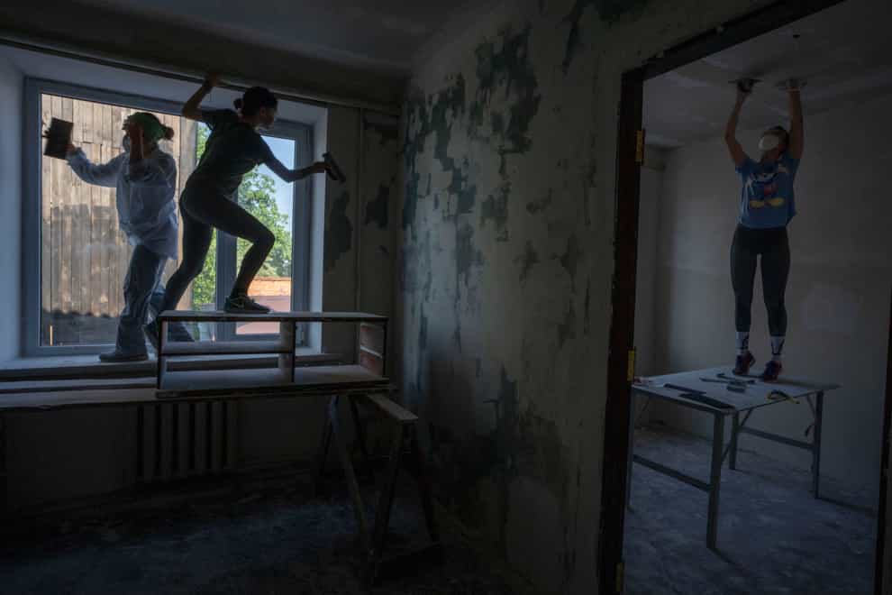Women work to reconstruct a damaged fire department from Russian strikes, in Makariv, Kyiv region (AP)