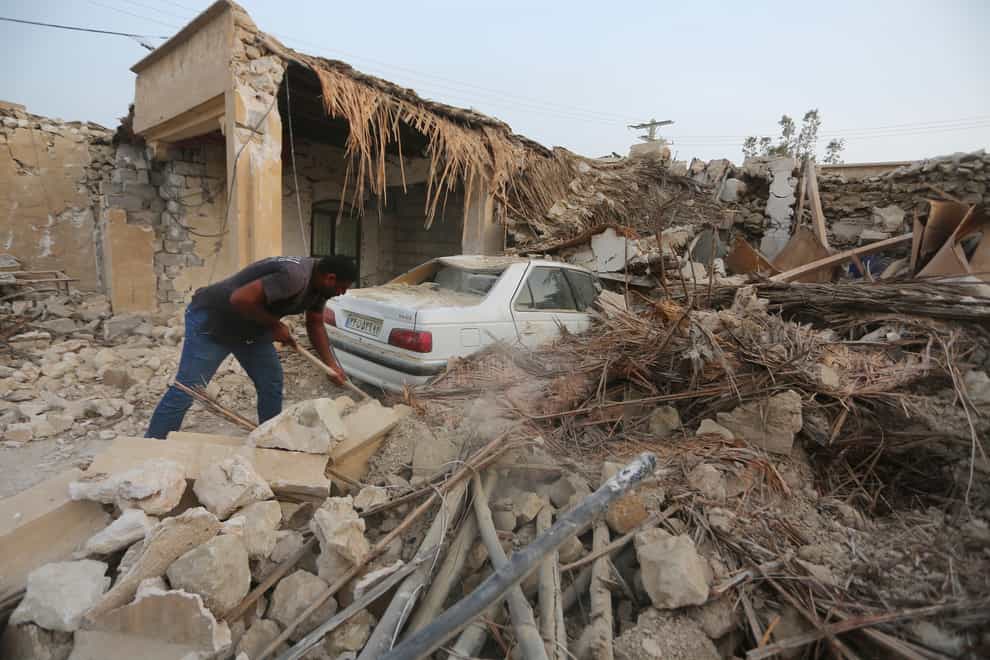 A man cleans up the rubble after an earthquake at Sayeh Khosh village in Hormozgan province (Abdolhossein Rezvani/AP)