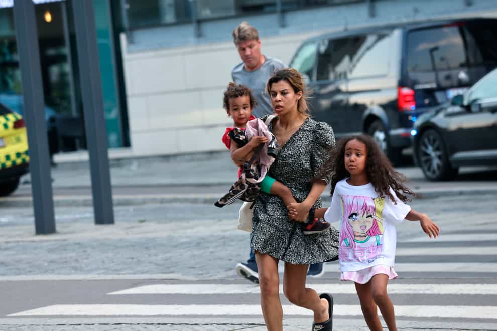 A woman and children flee the Field’s shopping centre in Copenhagen (Olafur Steinar Gestsson/Ritzau Scanpix via AP)