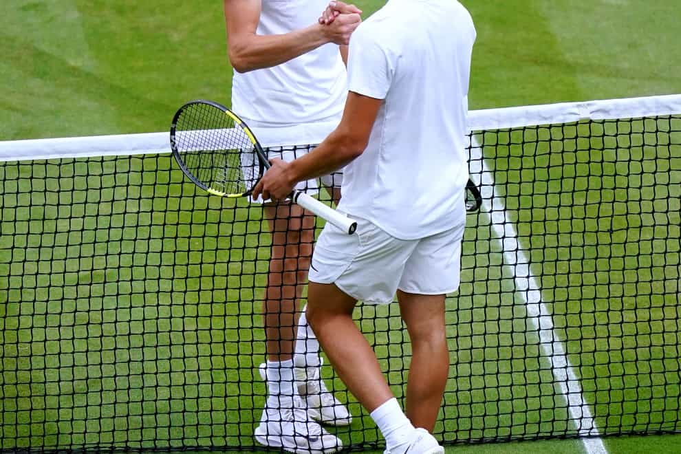 Jannik Sinner shakes hands with Carlos Alcaraz after winning their fourth-round match at Wimbledon (John Walton/PA)