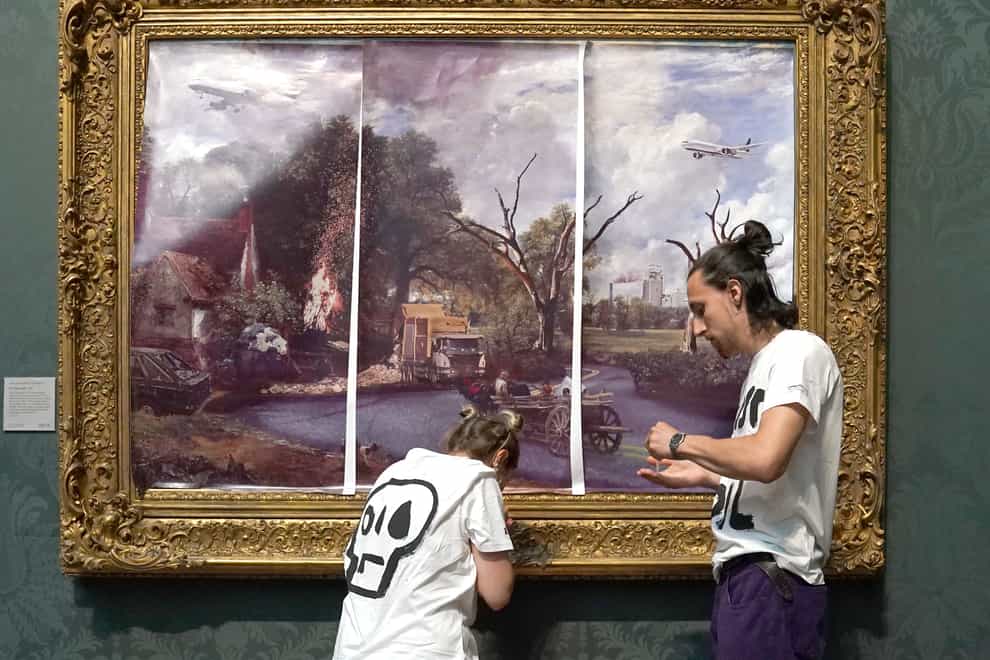Protesters from Just Stop Oil climate protest group, cover John Constable’s The Hay Wain with their own picture at the National Gallery, London (PA)