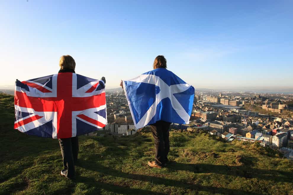 Scottish and English flags held up over Edinburgh, Scotland, as more than half of people in Scotland do not want another independence referendum next year, according to a new poll. First Minister Nicola Sturgeon has announced plans for a second vote on the issue on October 19 2023 (David Cheskin/PA)