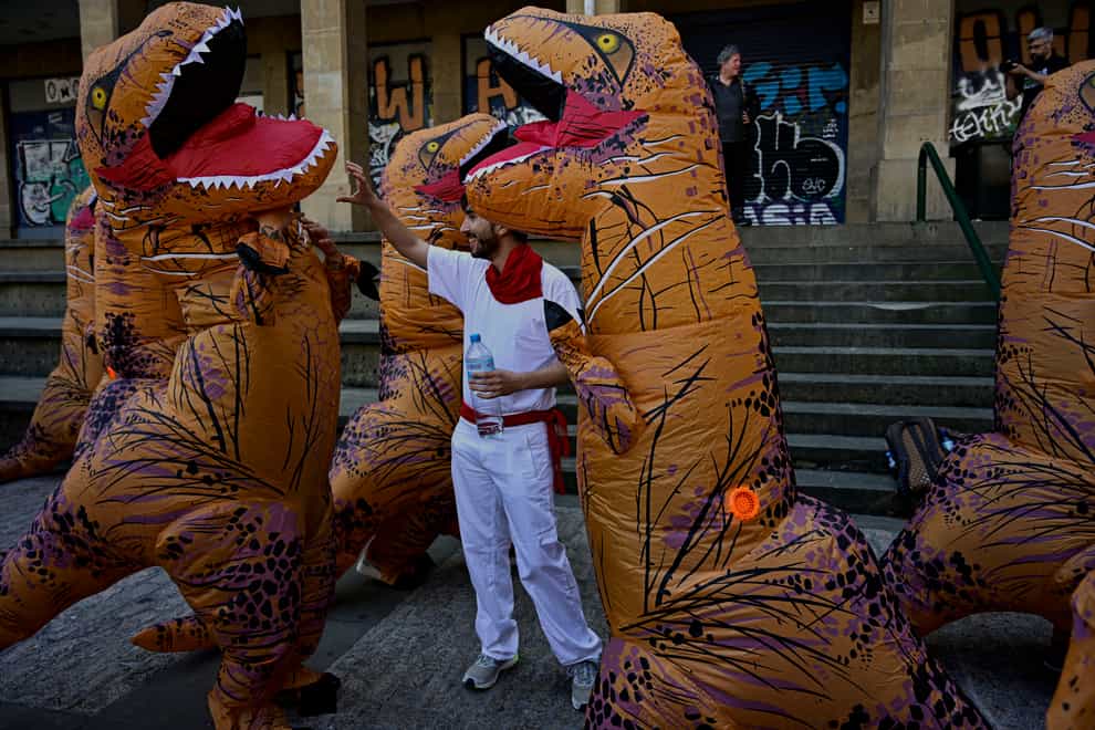 People dressing as dinosaurs protest against animal cruelty before the start of the San Fermin festival (AP)
