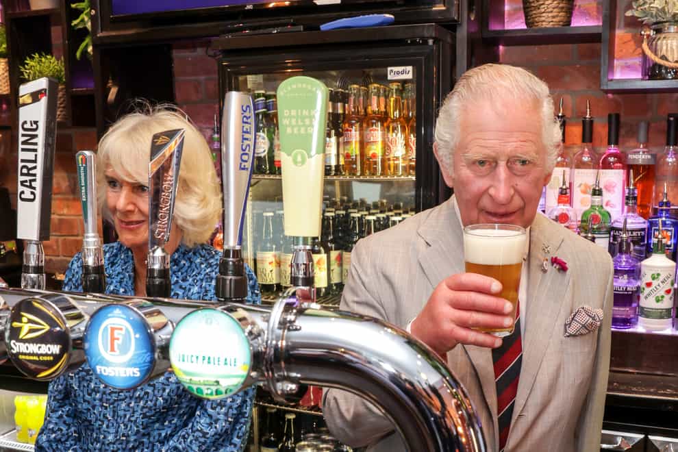 The Prince of Wales behind the bar at The Lion pub (Chris Jackson/PA)