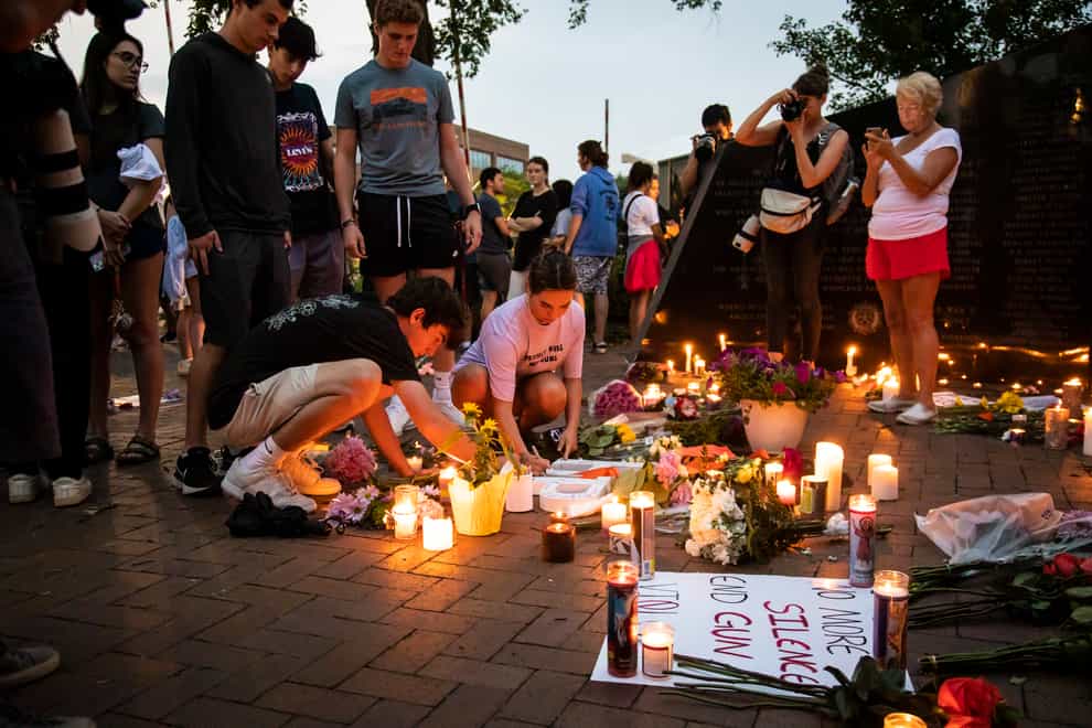 Dozens of mourners gather for a vigil near Central Avenue and St Johns Avenue in Highland Park (Anthony Vazquez/Chicago Sun-Times/AP)