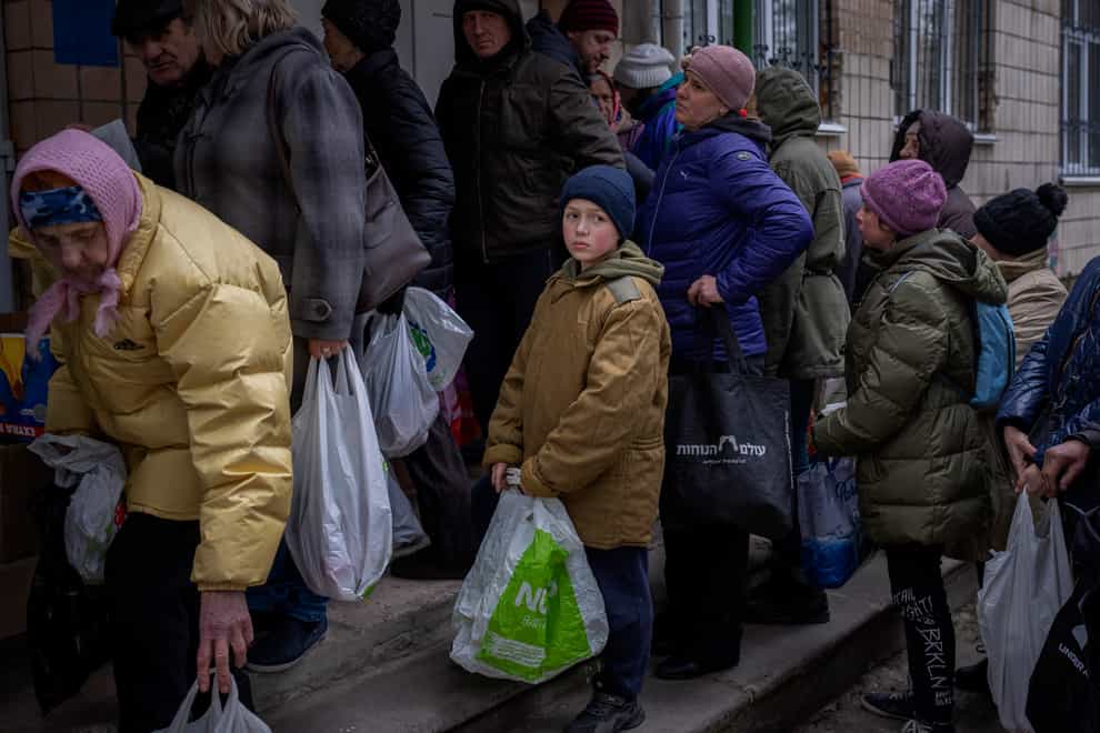 Sergei, 11, waits his turn to receive donated food during an aid humanitarian distribution in Bucha, in the outskirts of Kyiv (Emilio Morenatti/AP)