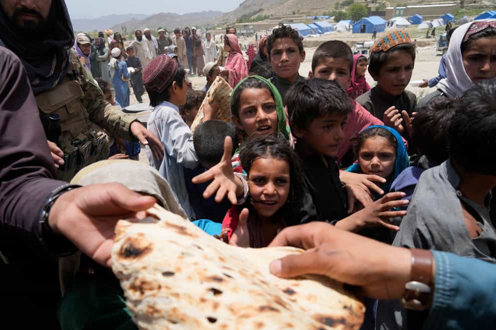 Afghans receive aid at a camp (AP)