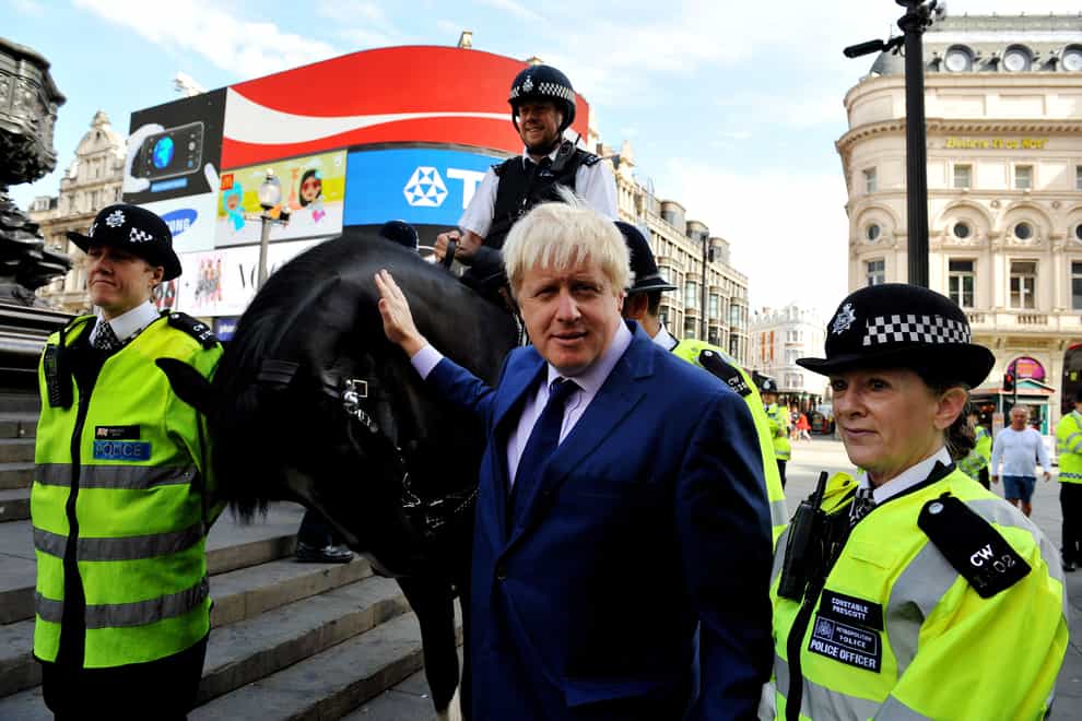 Mayor of London Boris Johnson strokes a police horse as he stands with officers by the Statue of Eros, Piccadilly Circus, London, during the launch of the Impact Zone Team for London’s West End.