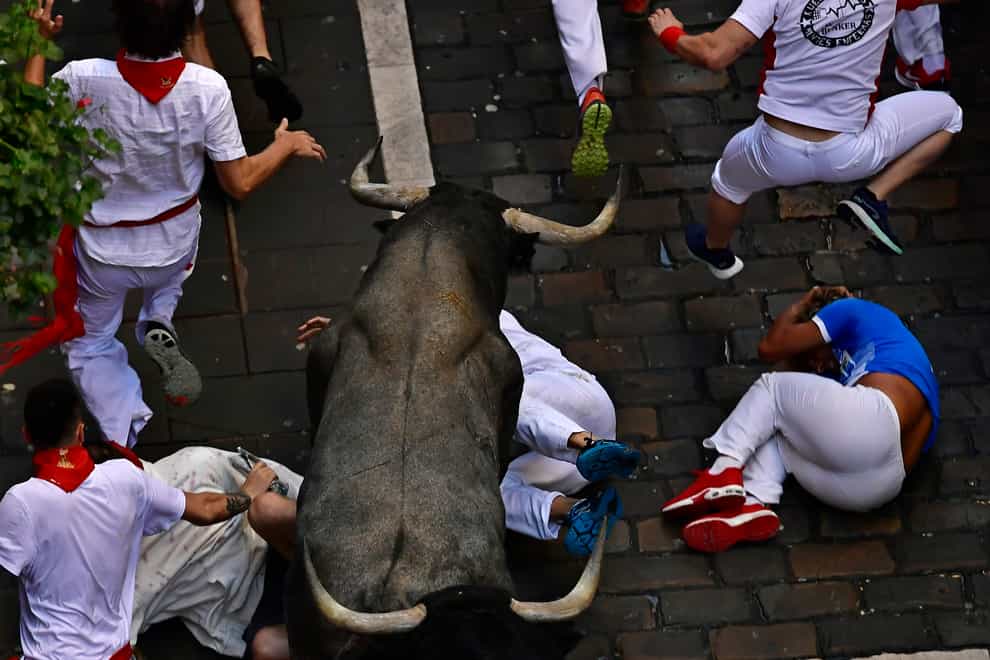 Runners fall during the running of the bulls at the San Fermin Festival in Pamplona, northern Spain (Alvaro Barrientos/AP)