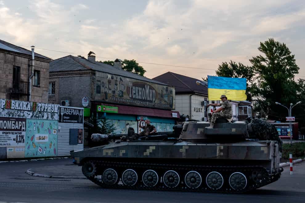 Ukrainian soldiers ride on a tank through a street in Pokrovsk, Donetsk region (Nariman El-Mofty/AP)