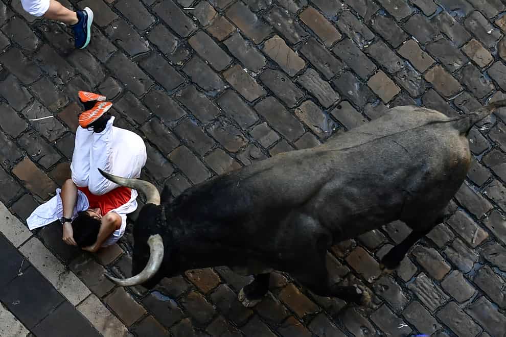 A runner falls during the running of the bulls at the San Fermin Festival in Pamplona, northern Spain (Alvaro Barrientos/AP)