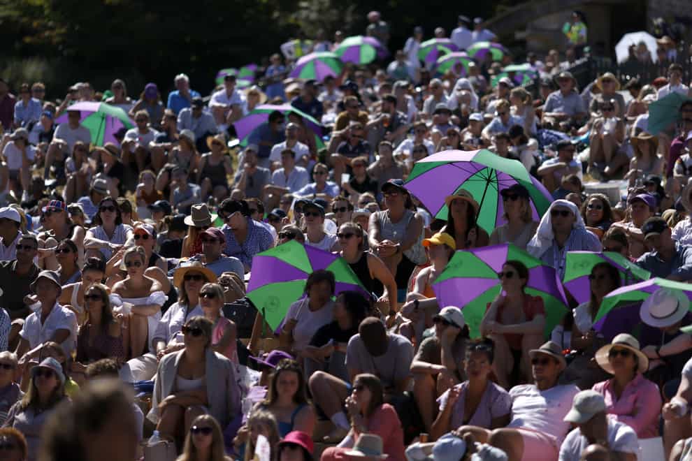 Spectators watch the action from the hill at Wimbledon (Steven Paston/PA)