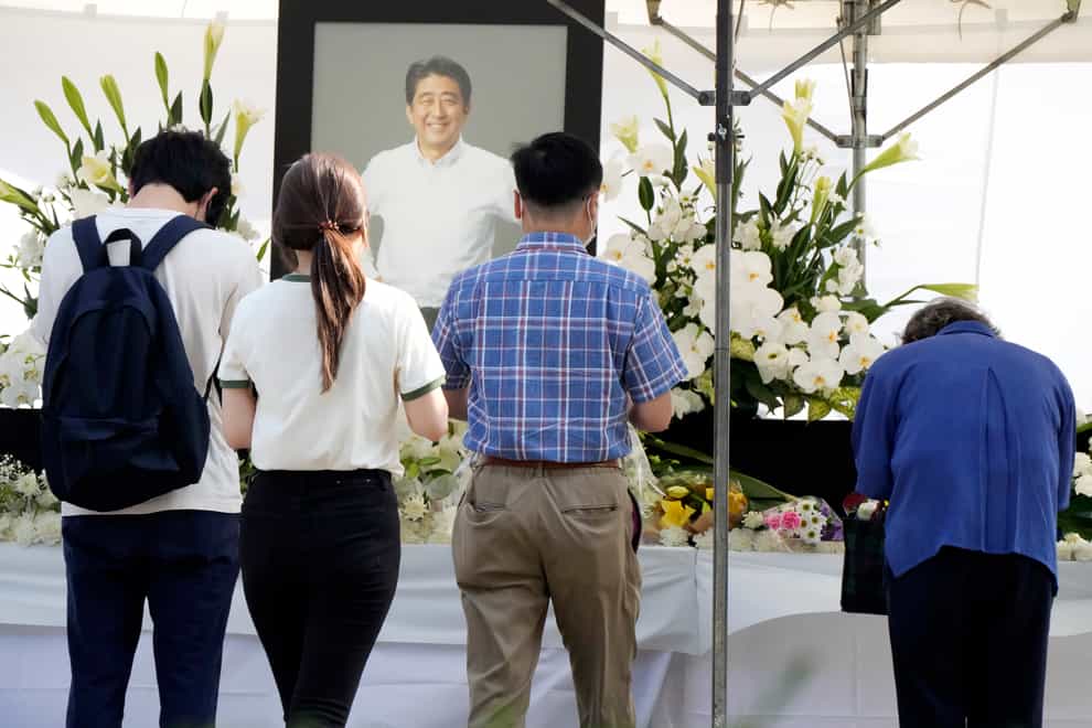 People offer flowers and prayers for former Prime Minister Shinzo Abe, at Zojoji temple prior to his funeral wake Monday, July 11, 2022, in Tokyo. Abe was assassinated Friday while campaigning in Nara, western Japan. (AP Photo/Eugene Hoshiko)