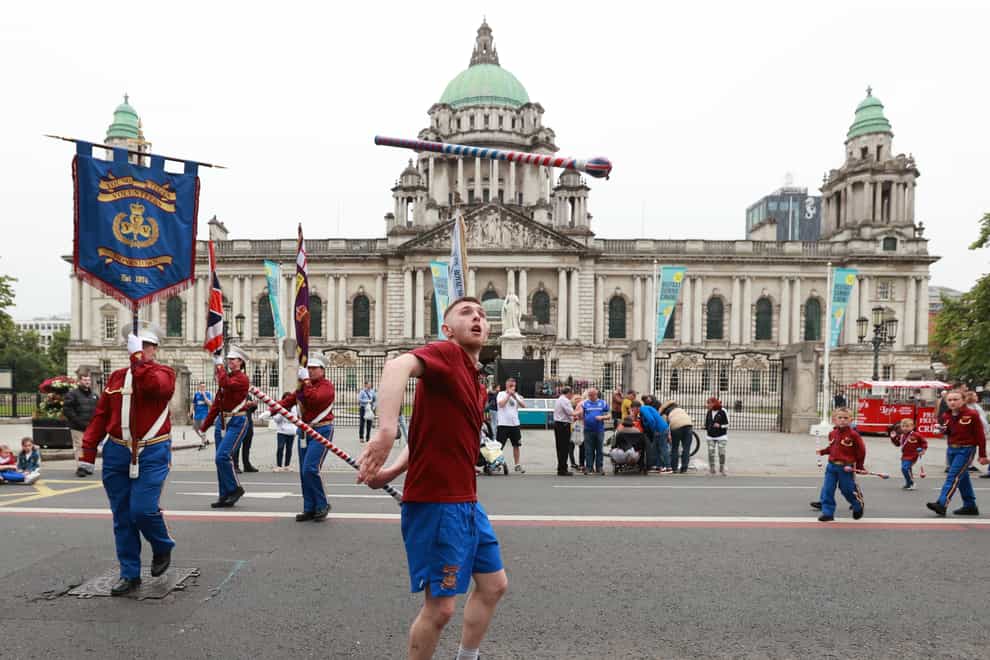 A drum major from Monkstown Young Citizen Volunteers throws a baton in the air in front of Belfast City Hall during the return leg of the Twelfth of July parade in Belfast, as part of the traditional Twelfth commemorations marking the anniversary of the Protestant King William’s victory over the Catholic King James at the Battle of the Boyne in 1690 (Liam McBurney/PA)