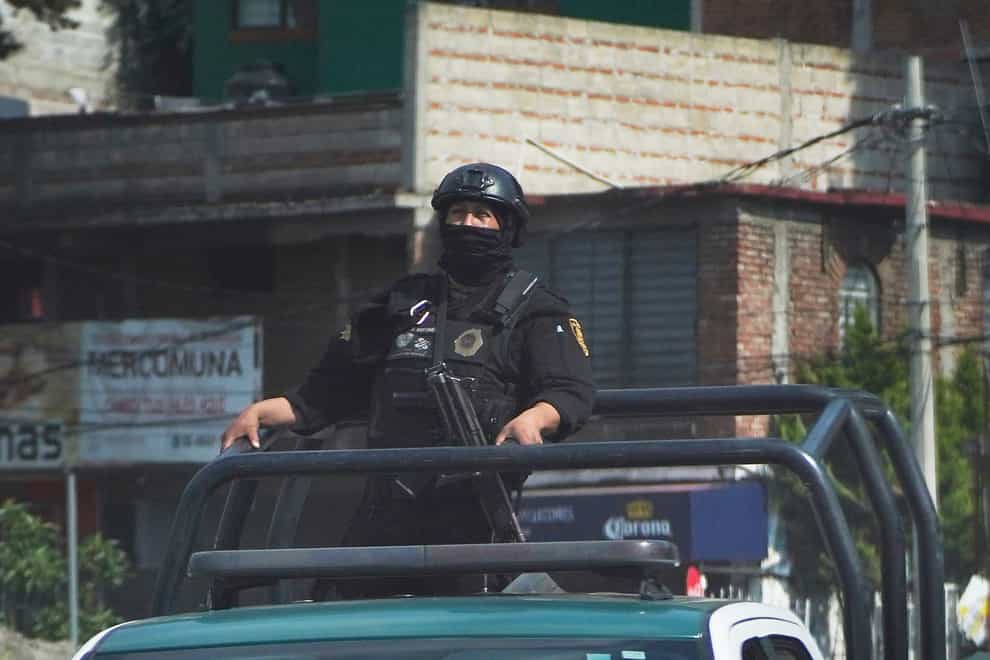 Police drive away after confrontations with what they claim were groups of criminals that left several in their ranks wounded, and more than a dozen persons detained, in Tupilejo, on the outskirts of Mexico City (Marco Ugarte/AP)