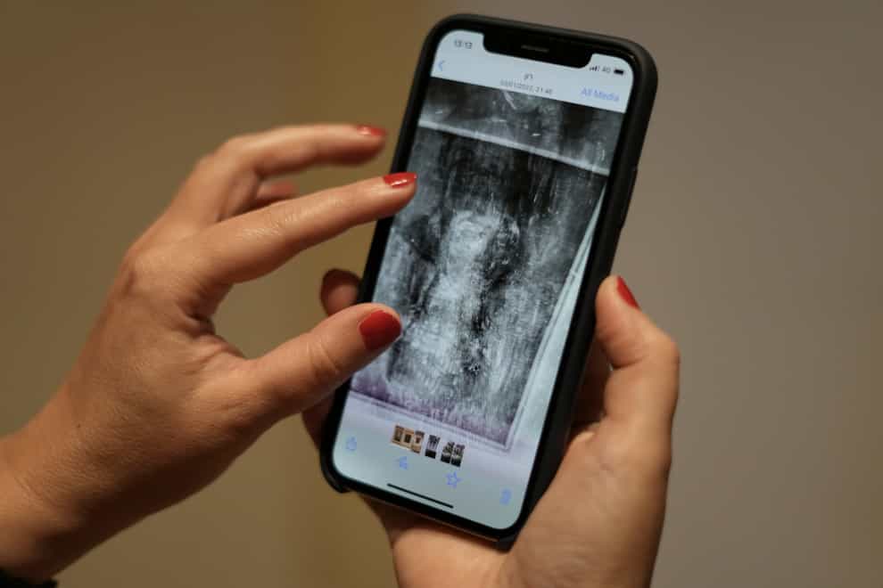 Art historian Inna Berkowits holds her mobile phone with an image of an X-ray of Amedeo Modigliani’s painting ‘Nude with a Hat’ (Ariel Schalit/AP)